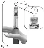 Una mano tiene una siringa con ago rivolto verso l'alto e un ingrandimento mostra la punta dell'ago che tocca il tappo di un flacone medico