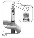 Close-up of a syringe held by a hand with an enlargement showing a drop of liquid falling from the tip of the