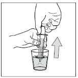 Two hands vertically lift a syringe out of a glass containing liquid, indicated by an upward-pointing arrow