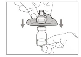 Una mano preme un dispositivo con un cappuccio verso il basso per inserirlo nel collo di un flacone di vetro tenuto dall'altra mano