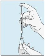 Una mano tiene verticalmente una siringa con ago inserito in un piccolo flacone di vetro tenuto dalla seconda mano su sfondo azzurro