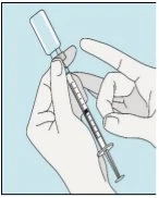 Due mani tengono una siringa con un flacone di farmaco collegato all'ago per preparare l'iniezione su sfondo azzurro