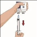 A hand holding a white medical device while the