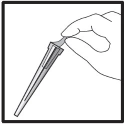 A hand holds the upper part of a thin, elongated cylindrical container tilted downward
