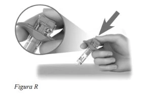 A hand holding a cylindrical medical device with an inset magnified view showing details of the top part and activation mechanism