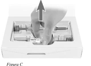 A hand lifts an Idacio drug vial from a white plastic container