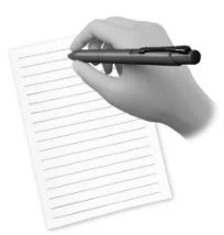 Una mano tiene una penna scura e scrive su un foglio di carta bianco a righe orizzontali inclinato verso sinistra