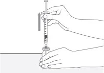 Una mano tiene una siringa e la spinge verso l'alto per aspirare il liquido da un flacone tenuto fermo dall'altra mano