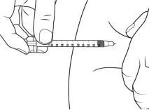 Una mano impugna una siringa orizzontale per iniettare il liquido nel tessuto adiposo della parte superiore della coscia di una persona