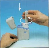 A hand holding a white and light blue medical device while the