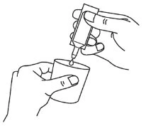 One hand holding a tube and pouring a drop of liquid into a small container held by the other hand