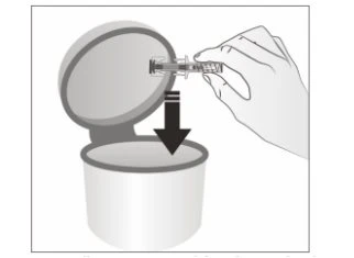 A hand inserts a syringe with a protected needle into the