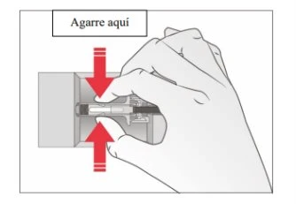 A hand grasps a medical device with fingers while two red arrows indicate the direction of pressure toward the center of the device
