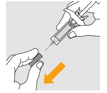 A hand holding a syringe with needle pointing toward a cap being removed with the