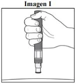 A hand holding vertically a pen-shaped medical device ready for use