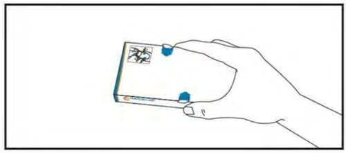 A hand holding a white medicine box with blue and yellow details to prepare the