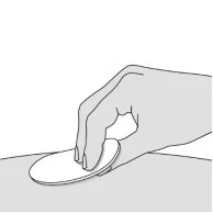A hand holds and presses a flat white circle onto the skin surface of the body for