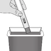 A hand holds an injection pen immersing the tip into a rectangular medical waste disposal container
