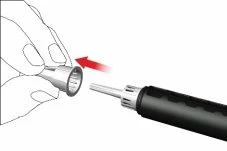 Ręka trzyma cylindryczną osłonkę, która zbliża się i zostaje włożona na górną część czarnego urządzenia medycznego z metalowym końcem