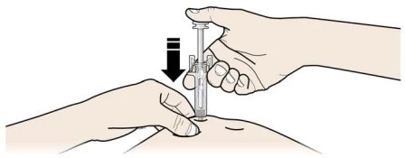 A hand holding a syringe in vertical position while the