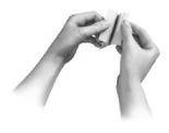 Two hands gently holding and folding a small light-colored rectangular container or wrapper on a white background