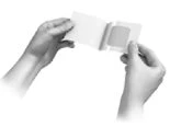 Two hands holding and opening a small white rectangular pouch or envelope to remove its contents