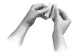 Two hands holding and gently folding a small white rectangular object or a sheet of flexible material against a neutral background