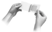 Two hands holding and opening a small plastic pouch or envelope to remove the medicinal contents inside