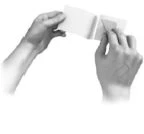 Two hands hold and unfold a folded patient information leaflet against a neutral white background