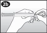 Two hands hold a syringe horizontally while a third hand removes the protective cap from the tip