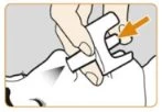 Una mano preme un dispositivo medico bianco sulla pelle con una freccia arancione che indica il punto di pressione sulla parte superiore