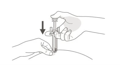 A hand holds a syringe vertically while the