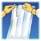 Due mani con guanti gialli tengono e aprono una busta di plastica trasparente che contiene tre sacche bianche allineate verticalmente