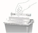 A hand holding a horizontal syringe above an open container for drug withdrawal or disposal