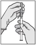 Two hands holding a syringe in vertical position to prepare the injection
