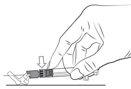A hand gripping a syringe with a downward-pointing arrow indicating the pressure to be applied to the plunger for injection