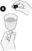 Una mano tiene un contenitore cilindrico sopra un bicchiere pieno di liquido mentre l