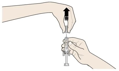 A hand holds the top part of a syringe while the