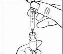 Una mano tiene una siringa graduata per aspirare il liquido da un piccolo flacone di vetro tenuto dall'altra mano