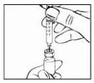 A hand holds a syringe with the needle pointing toward the neck of a small glass vial held by the