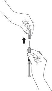 A hand lifting a medication vial to place it above the
