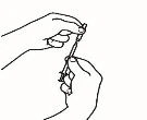 Two hands holding and manipulating a syringe with needle to prepare or administer a liquid medication