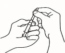 Two hands holding and preparing a syringe with needle and vial for medication