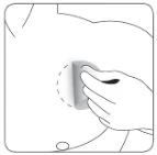 Line drawing of a hand holding a cylindrical medical device pressed against the abdominal area of a human torso, indicated by a dotted line