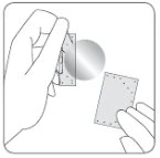Two hands separating two small perforated rectangular sheets from a faded gray circle indicating the detachment point between the two pieces
