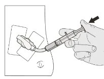 Una mano impugna una siringa con un ago che viene inserito in un dispositivo applicatore posizionato su una superficie piana