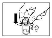 Una mano preme verso il basso il tappo di un flaconcino di medicinale vicino all'orecchio per ascoltarne il suono durante l'apertura
