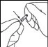 Two hands holding and manipulating a small cylindrical medical device indicated by an arrow pointing towards it