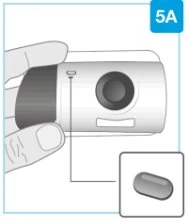 A hand holding a cylindrical white medical device with a vertical line indicator and a prominent dark circular button