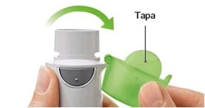A hand removing a green cap from a white medical device following the direction indicated by a curved green arrow
